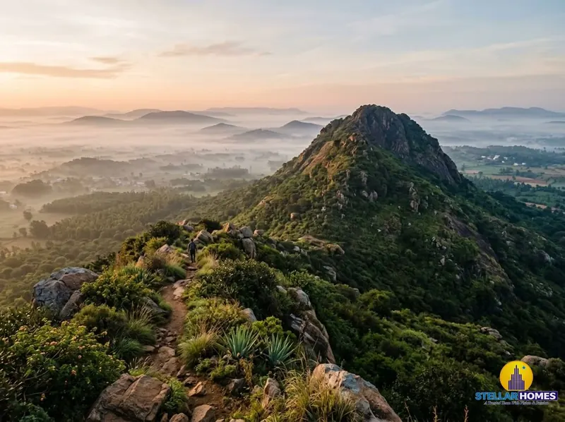 Boulder-strewn hillside trail at Kalavara Betta with panoramic views over the Nandi Hills range